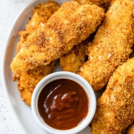 a plate of crispy air fryer chicken tenders with dipping sauce