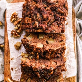 Moist and healthy apple bread with fresh apples and walnuts cut into slices on parchment paper