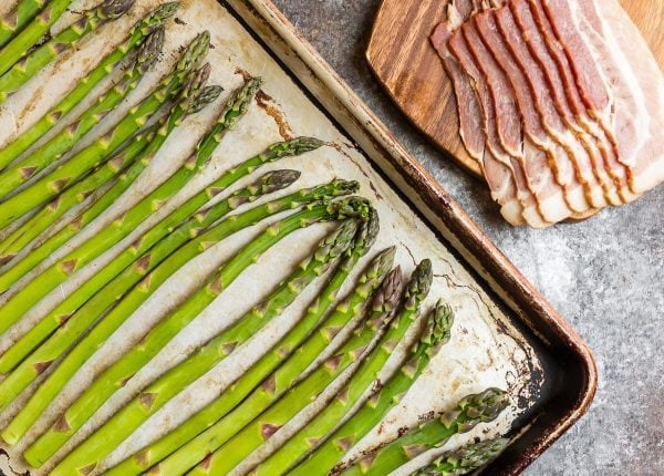 Bacon Wrapped Asparagus being assembled on a baking sheet