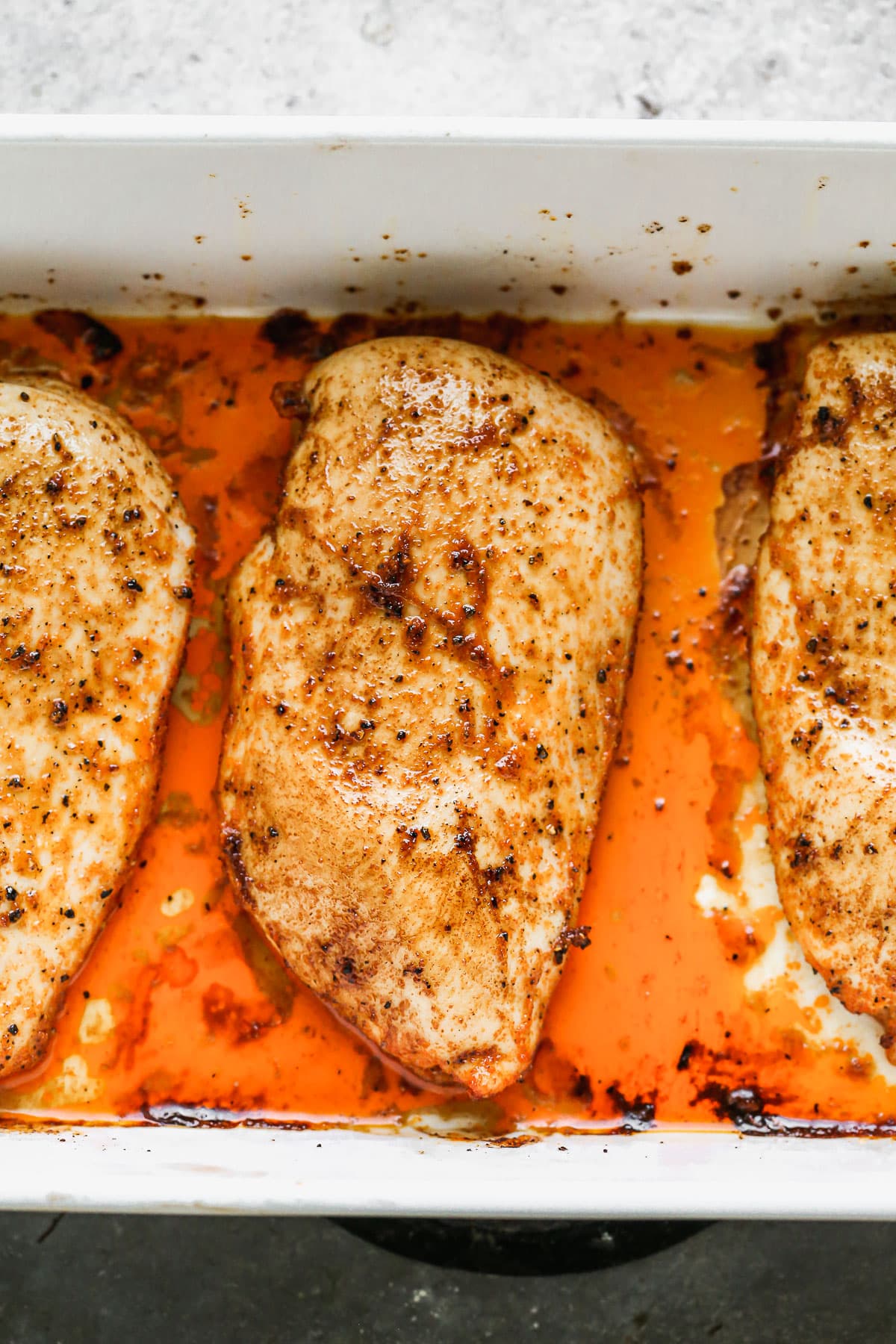 Three chicken breasts in a baking dish