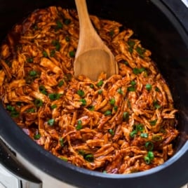 slow cooker bbq chicken shredded in a crockpot with barbecue sauce