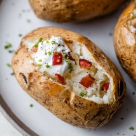 baked potatoes on plate with toppings