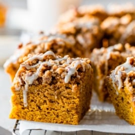 a slice of moist pumpkin coffee cake with streusel crumb topping and glaze