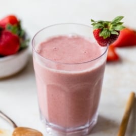 the BEST strawberry smoothie recipe EVER in a glass with strawberries