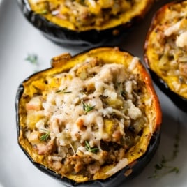 stuffed acorn squash with sausage and cheese on a plate