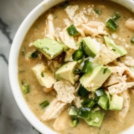 white chicken chili in bowl with toppings