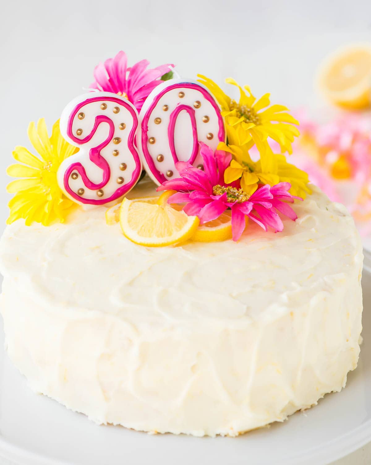 A simple lemon cake recipe decorated with cream cheese frosting, flowers, and candles