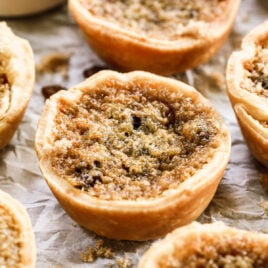 Butter Tarts with flakey pie crust and sweet filling on a piece of parchment paper