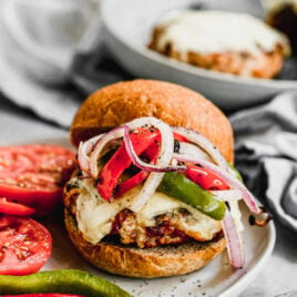 Italian turkey burger with cheese and vegetables on a white plate