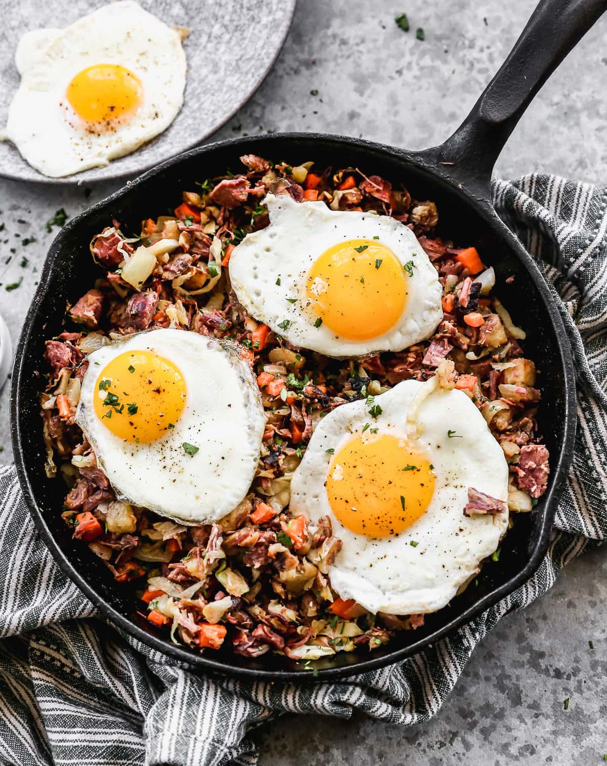 corned beef hash with three eggs in a skillet