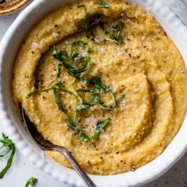 Bowl of creamy polenta topped with basil