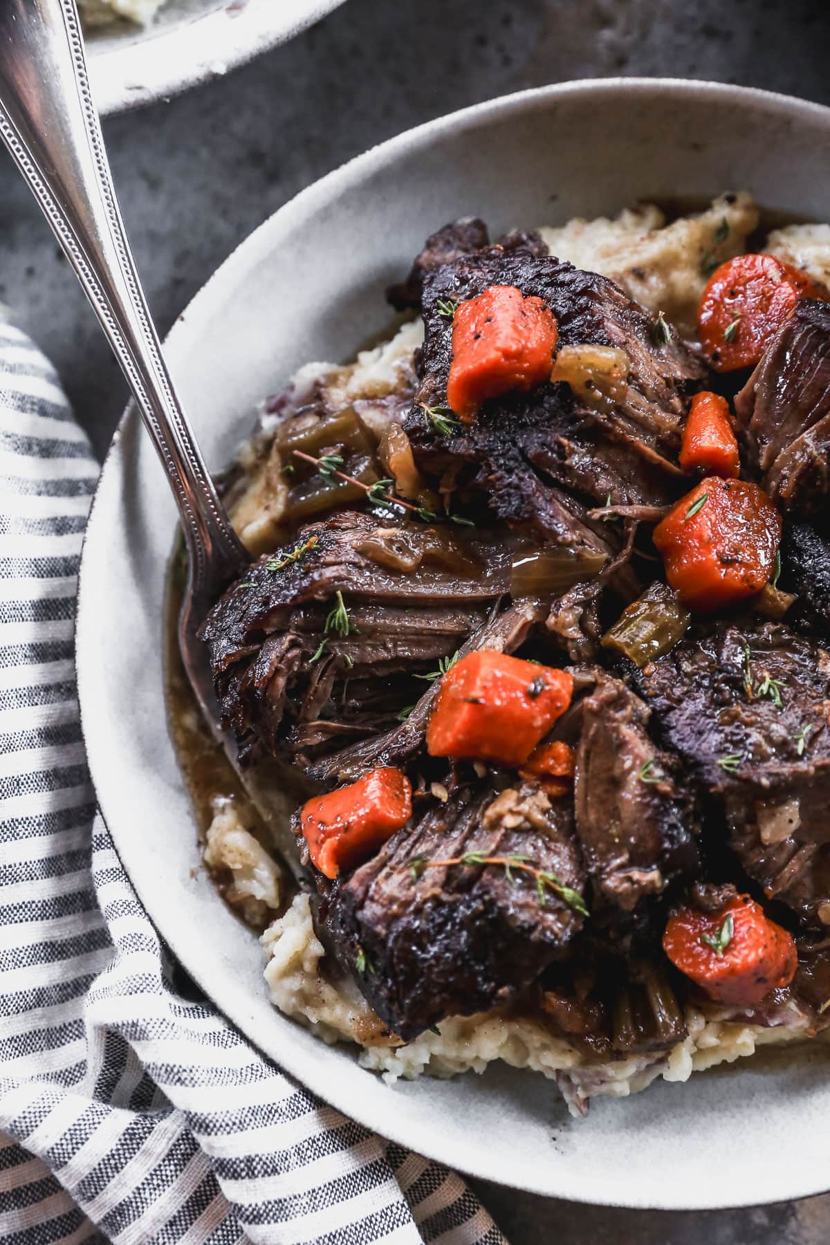 bowl of mashed potatoes topped with red wine braised beef