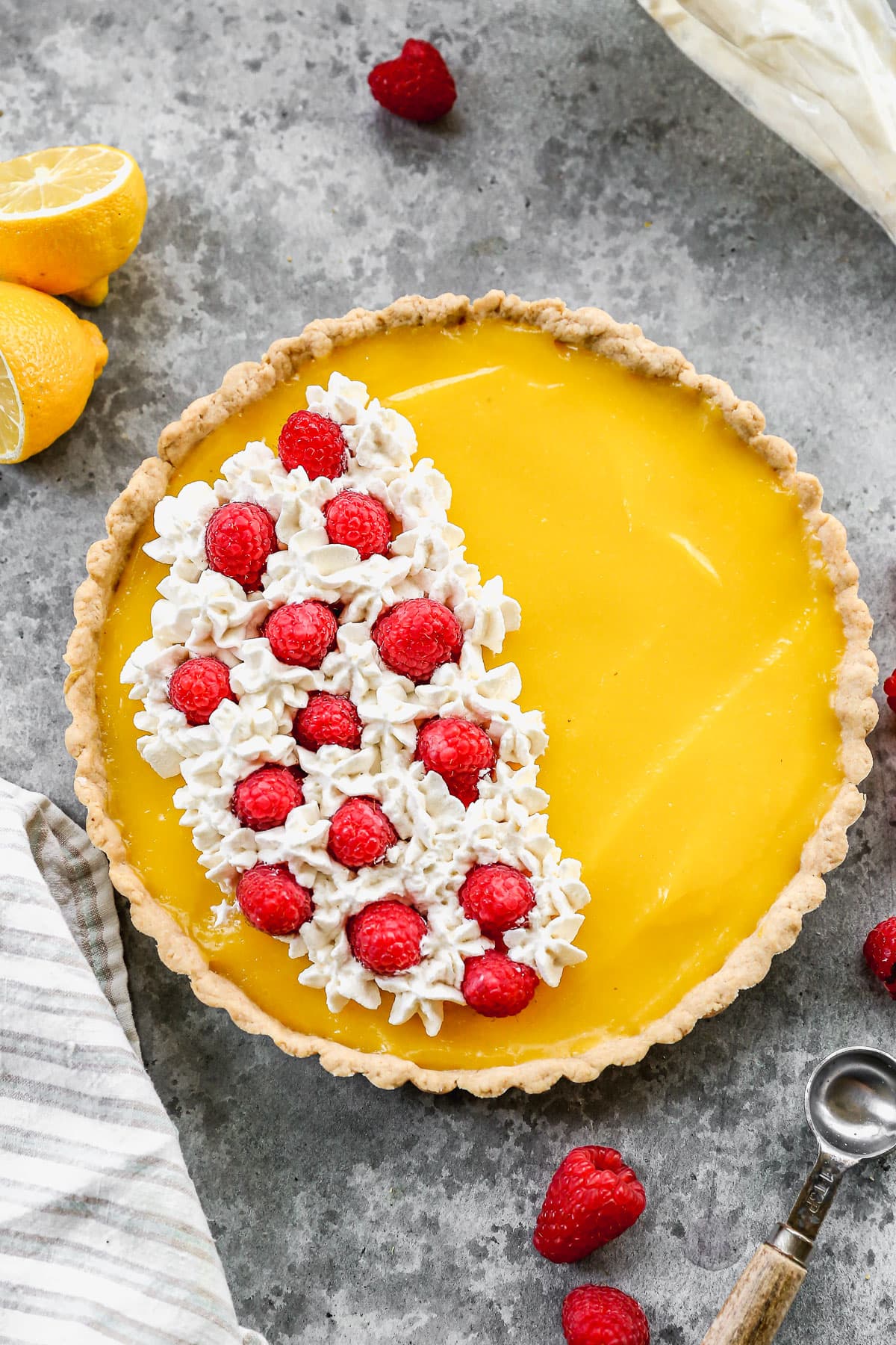 classic lemon tart topped with whipped cream and berries
