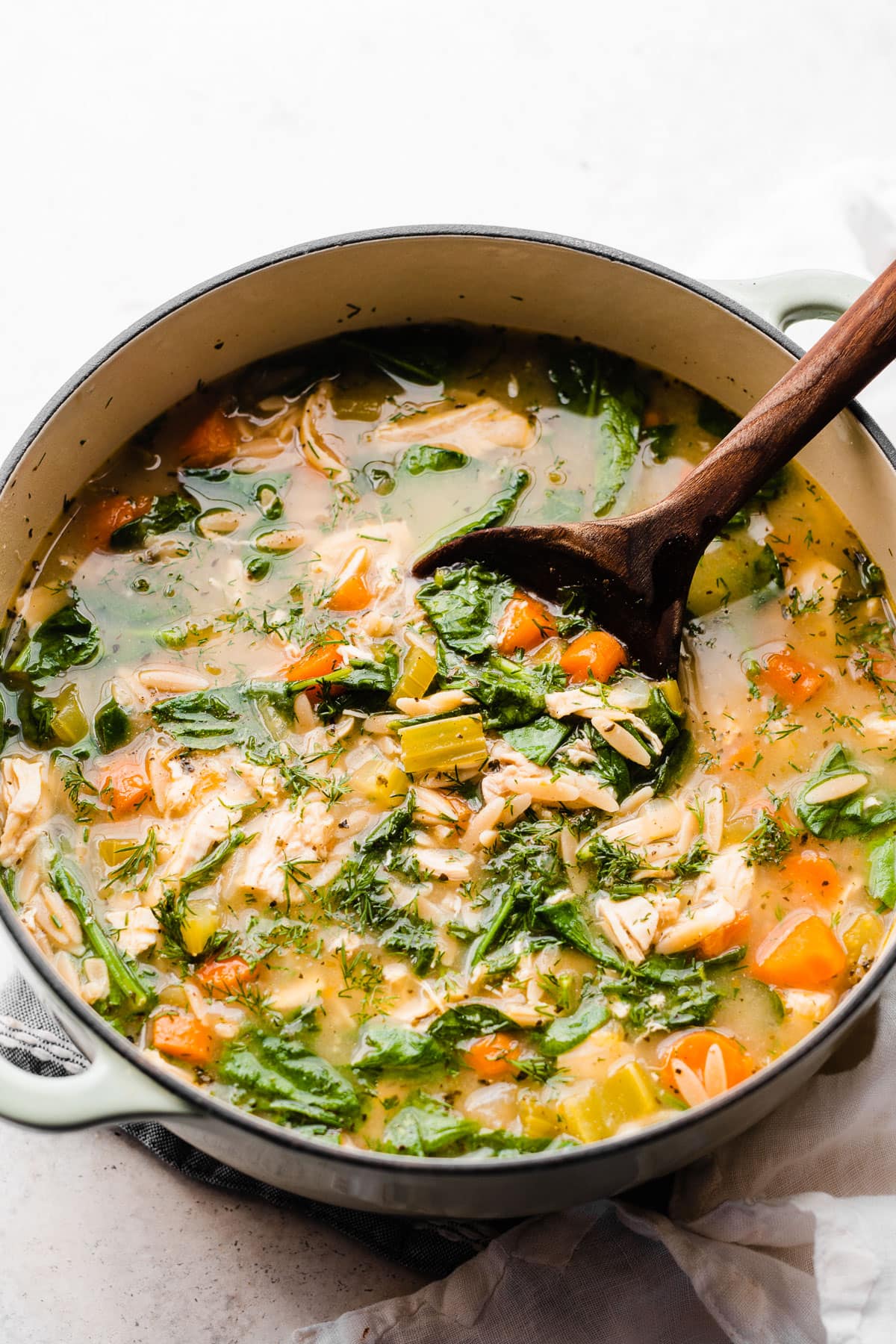 A pot of Greek lemon chicken orzo soup with vegetables