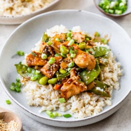 A bowl of General Tso chicken with rice and veggies