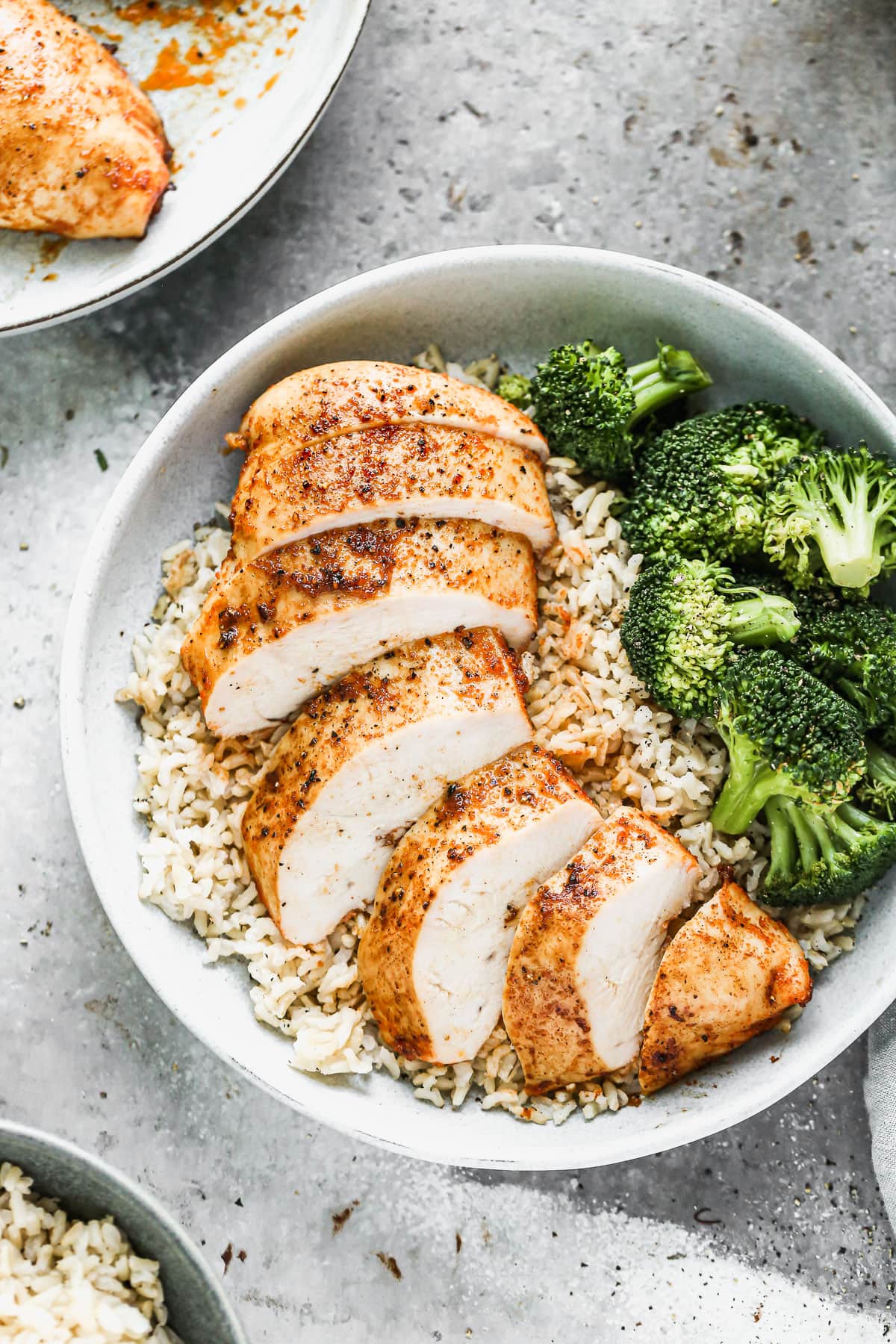 A sliced chicken breast with rice and broccoli
