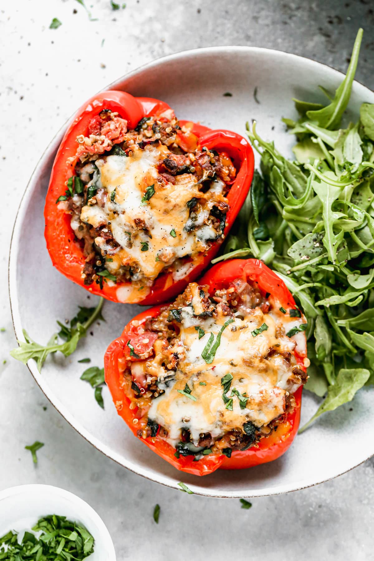 The BEST stuffed peppers on a plate with arugula salad