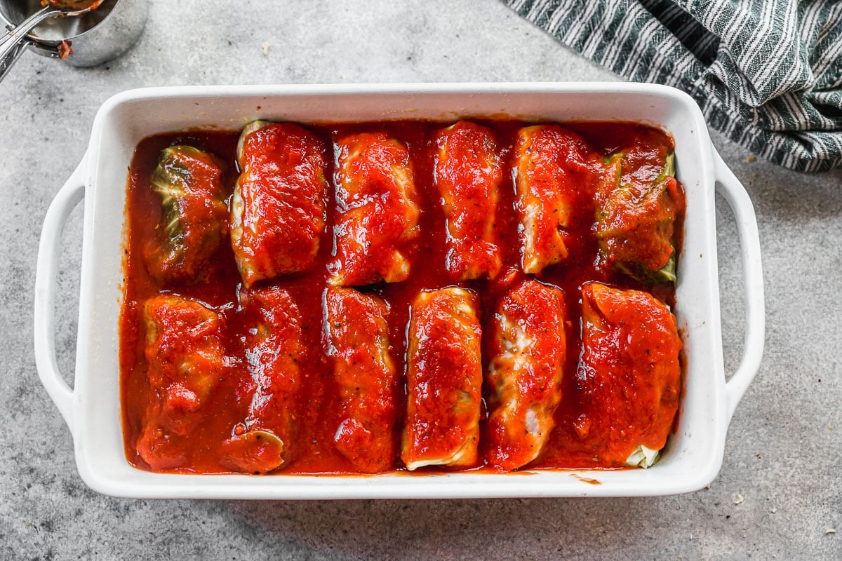 cabbage rolls with sauce in baking dish