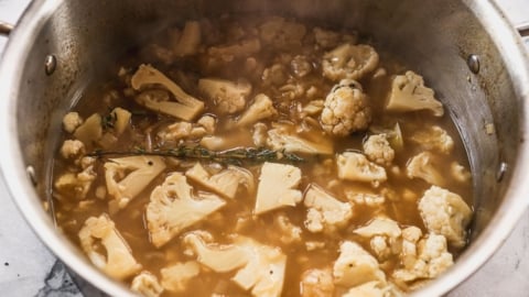 cauliflower simmered in pot of broth