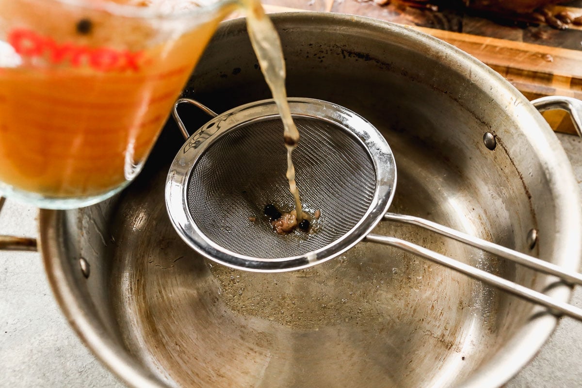 pouring broth through sieve