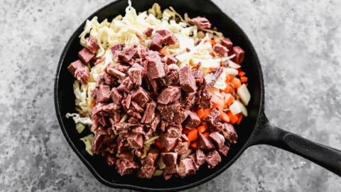 corned beef hash ingredients on a large skillet