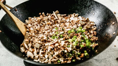 a wok of ground turkey and finely chopped mushrooms and green onions