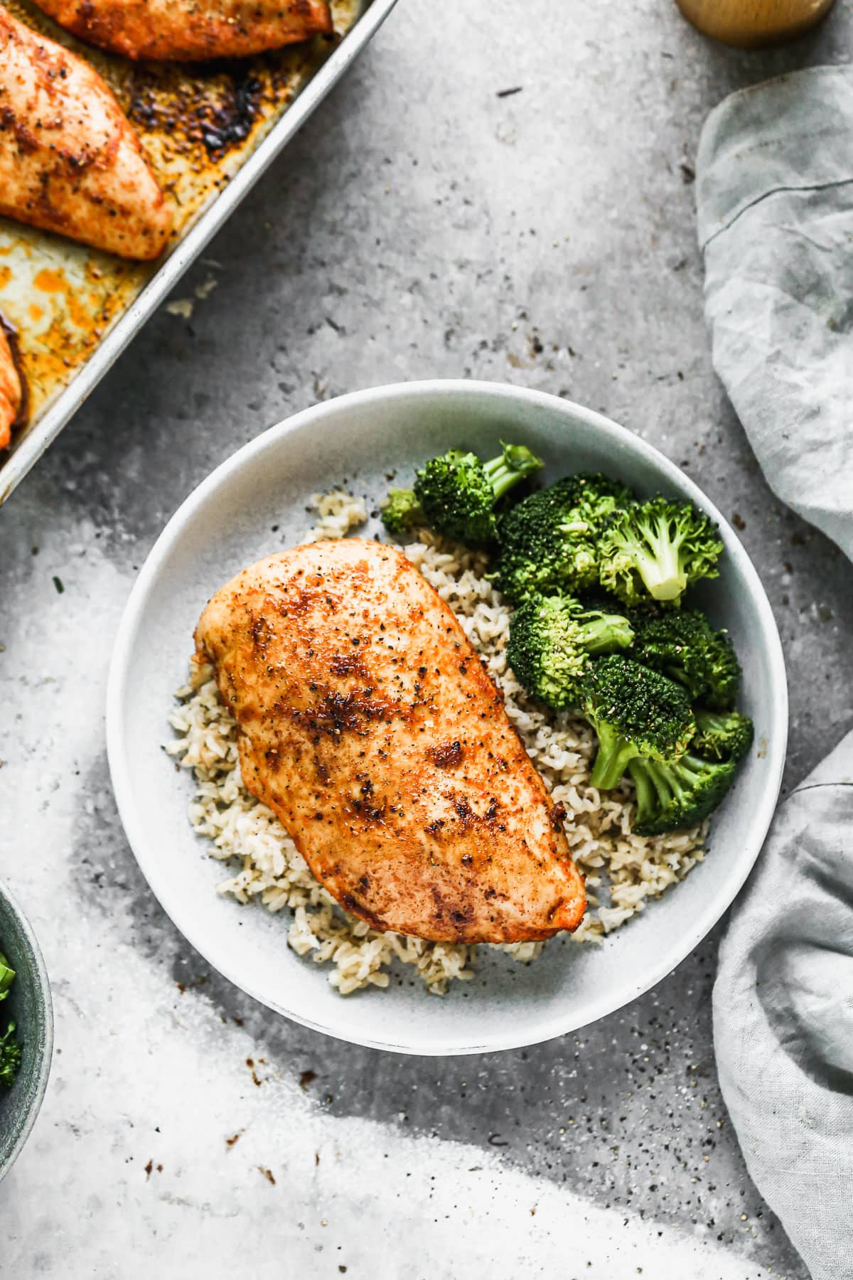 Oven roasted chicken breast in a bowl with rice and broccoli
