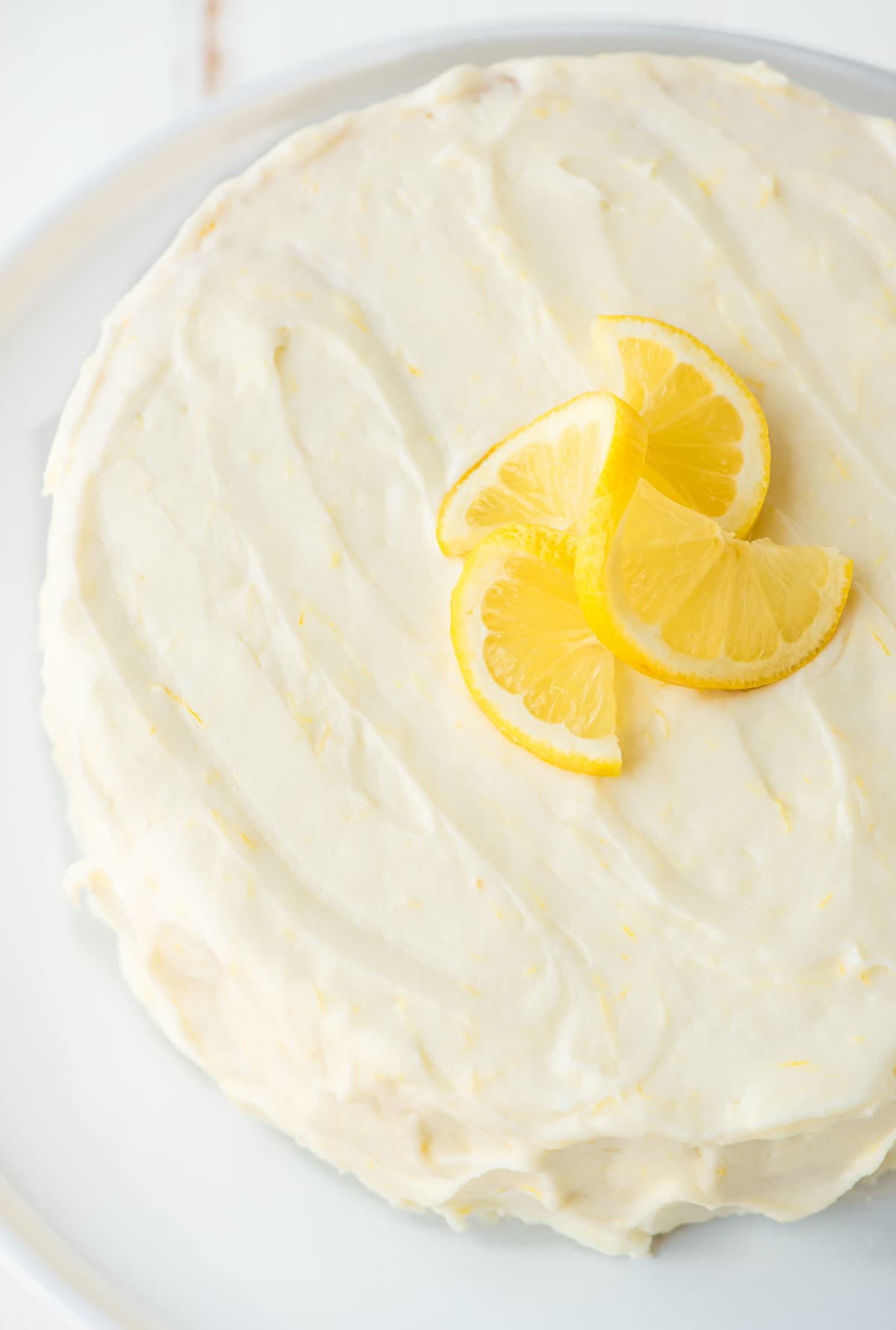 lemon layer cake recipe frosted with lemon cream cheese frosting, topped with fresh lemon slices