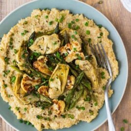 Vegan risotto on a blue plate with artichokes