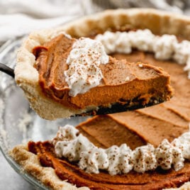 a slice of no bake pumpkin pie vegan being removed from a whole pie