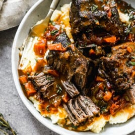Red wine braised short rib pasta with mashed potatoes in a gray bowl