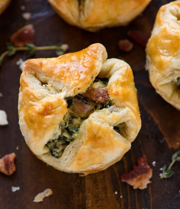 Easy, delicious Spinach Puffs are golden, buttery, and baked to perfection! These spinach puff pastry cups are filled with spinach, cream cheese, feta, and bacon for an irresistible make-ahead holiday party appetizer.