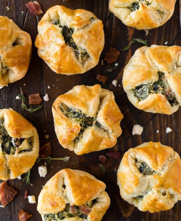 The best Spinach Puffs for your holiday parties! This easy puff pastry appetizer is filled with cream cheese, spinach, feta, and bacon, for a delicious snack that tastes like everyone's favorite spinach dip.