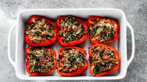 Uncooked stuffed peppers in a baking dish