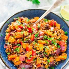 Roasted Sweet Potato Quinoa Black Bean Salad in a large blue serving bowl with a serving spoon in the dish.