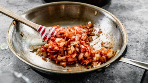 Onion, garlic, and tomato paste cooking in a skillet